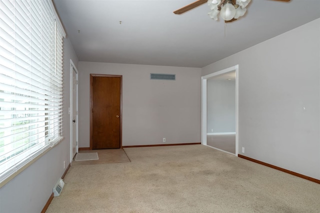 spare room featuring light colored carpet and ceiling fan