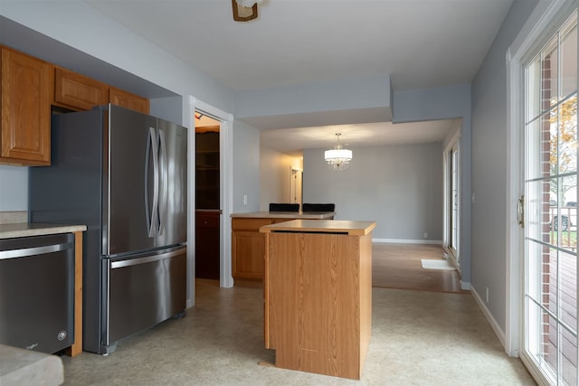 kitchen featuring pendant lighting, appliances with stainless steel finishes, and an inviting chandelier