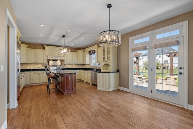 kitchen featuring pendant lighting, plenty of natural light, light hardwood / wood-style floors, and a kitchen island