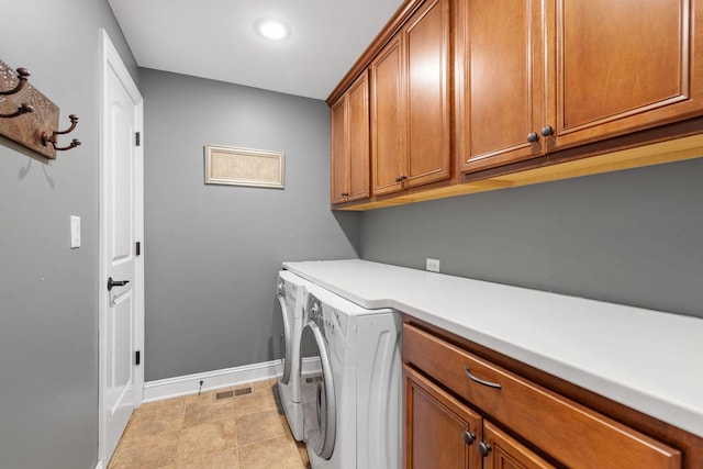 laundry area featuring cabinets, light tile patterned floors, and washing machine and dryer