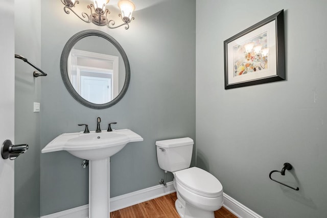 bathroom featuring sink, wood-type flooring, and toilet