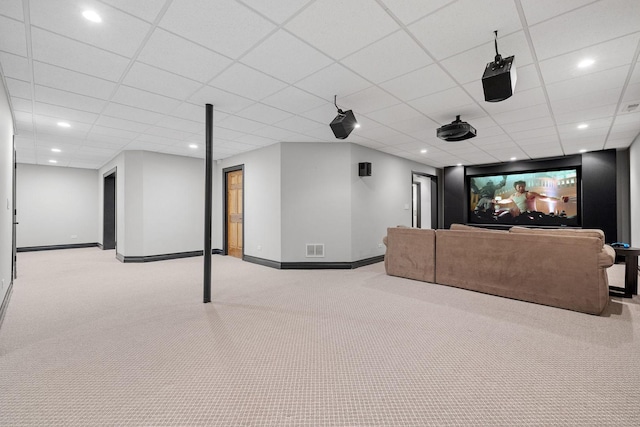 cinema room with a drop ceiling and light colored carpet