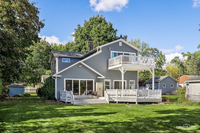 rear view of property with a yard, a wooden deck, and a balcony