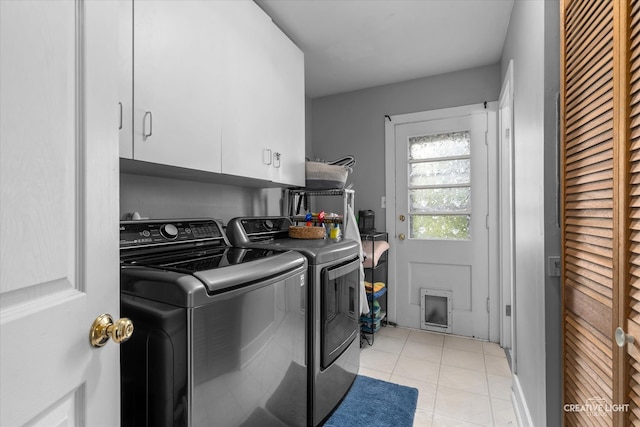 laundry room with light tile patterned floors, cabinets, and independent washer and dryer