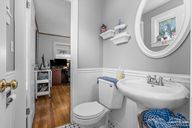 bathroom featuring crown molding, wood-type flooring, and toilet