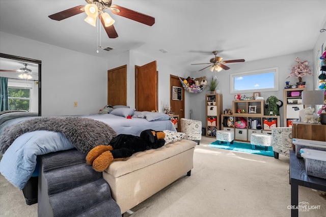 bedroom with multiple windows, light colored carpet, and ceiling fan