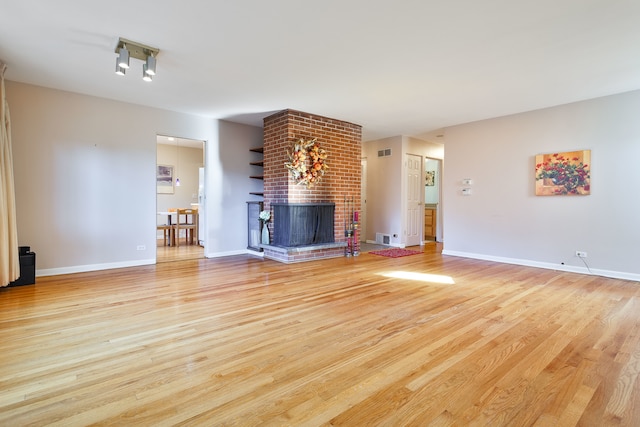 unfurnished living room featuring a fireplace and light wood-type flooring