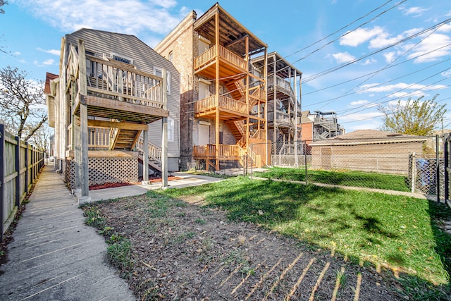 rear view of house featuring a yard and a deck