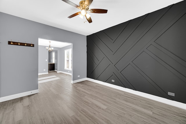 unfurnished living room with hardwood / wood-style flooring and ceiling fan with notable chandelier