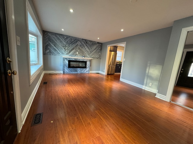 unfurnished living room featuring hardwood / wood-style floors and a high end fireplace