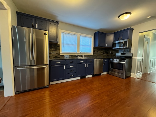 kitchen featuring dark hardwood / wood-style flooring, sink, appliances with stainless steel finishes, and tasteful backsplash