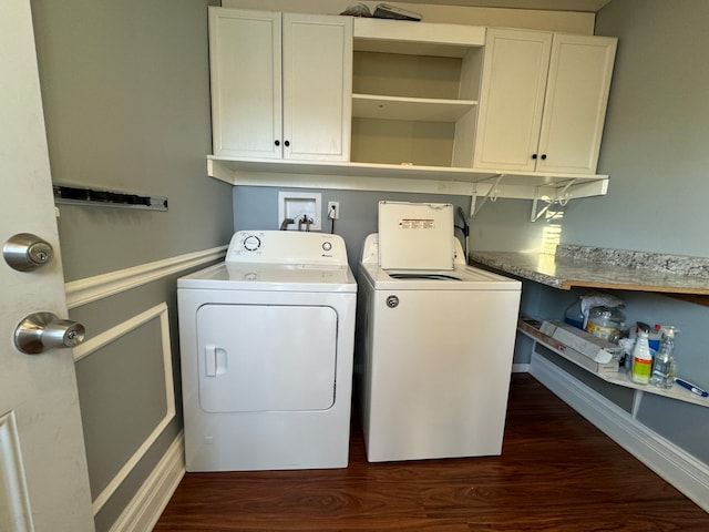 laundry room with cabinets, washing machine and dryer, and dark wood-type flooring