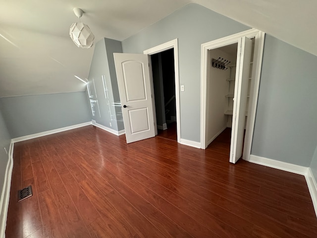 additional living space featuring vaulted ceiling and dark hardwood / wood-style floors