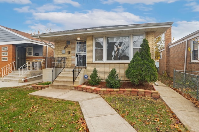 bungalow-style home featuring covered porch and a front lawn