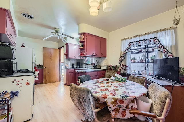 dining space with ceiling fan with notable chandelier, light hardwood / wood-style floors, and sink