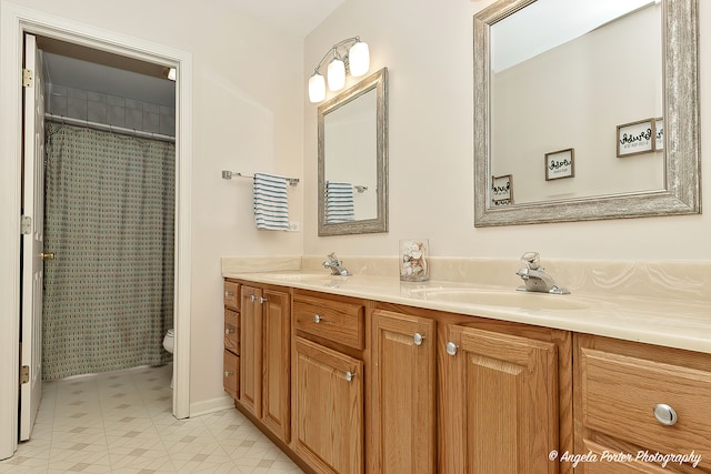 bathroom with tile patterned flooring, vanity, toilet, and walk in shower