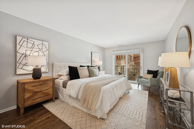 bedroom with baseboards, access to outside, and wood finished floors