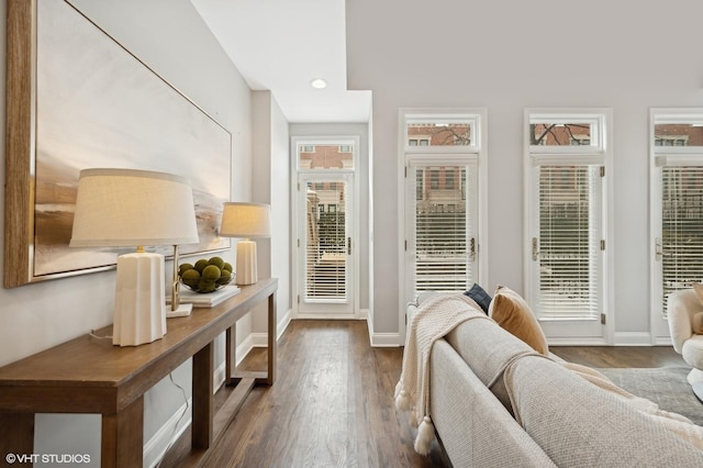 doorway to outside featuring baseboards and dark wood finished floors