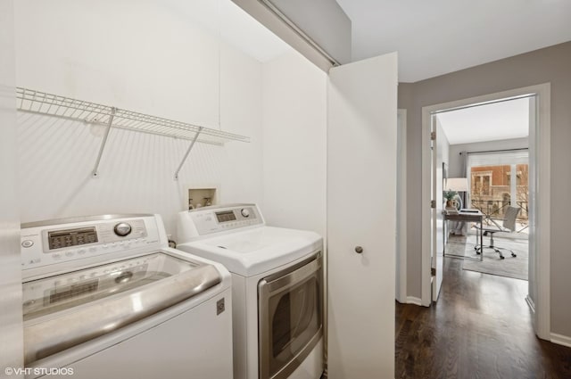 laundry area with washer and clothes dryer, dark wood-type flooring, and laundry area