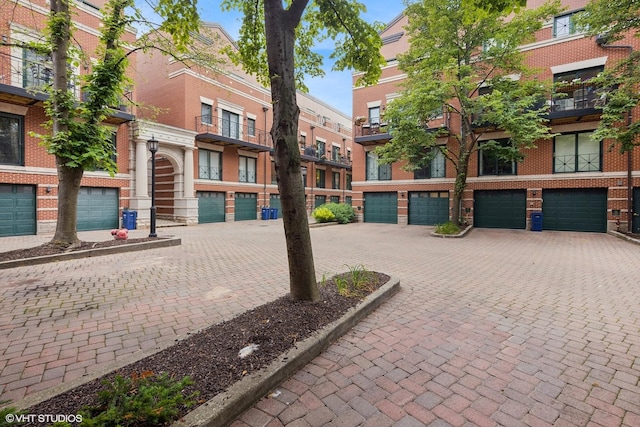 view of property's community with a garage and decorative driveway