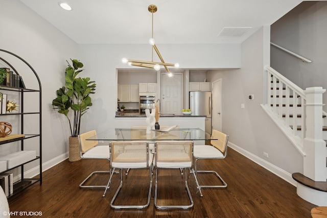 dining room featuring dark wood finished floors, baseboards, an inviting chandelier, and stairway