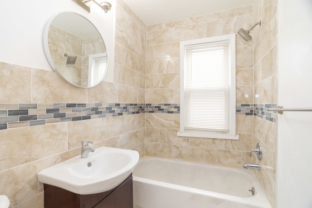 bathroom with vanity, tile walls, and tiled shower / bath