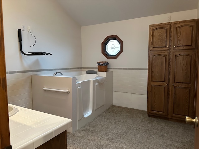 laundry room with light carpet and tile walls