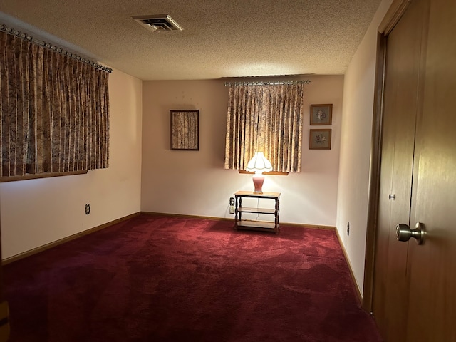 spare room featuring carpet and a textured ceiling