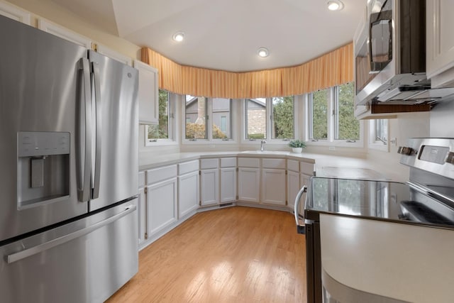 kitchen with sink, white cabinets, stainless steel appliances, and light hardwood / wood-style floors