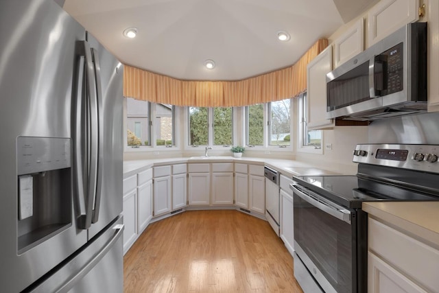 kitchen featuring white cabinets, sink, light wood-type flooring, and stainless steel appliances