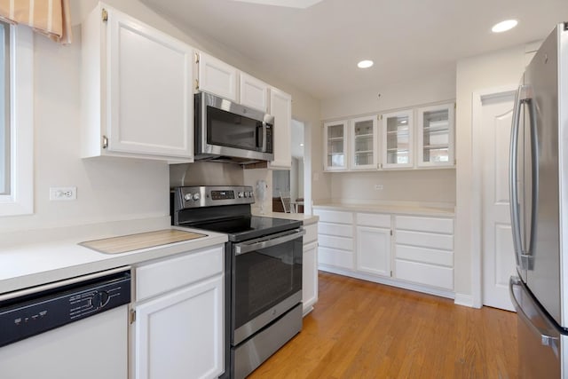 kitchen with white cabinets, stainless steel appliances, and light hardwood / wood-style flooring