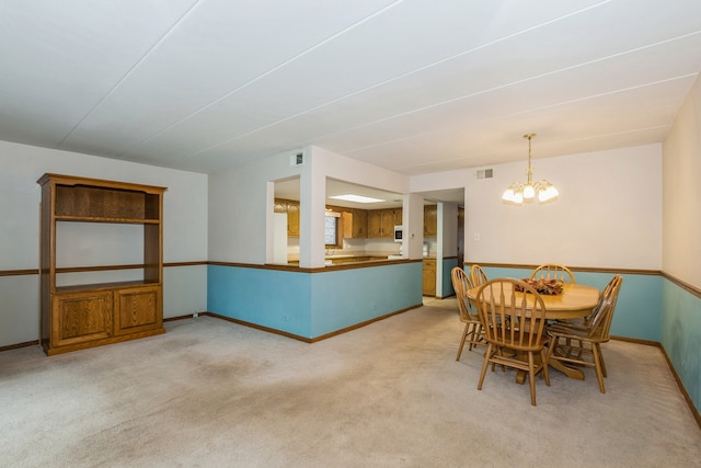 dining space with a chandelier and light carpet