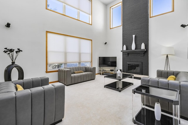 carpeted living room with a high ceiling and a brick fireplace