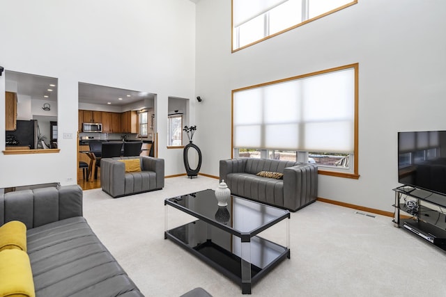 carpeted living room featuring a high ceiling