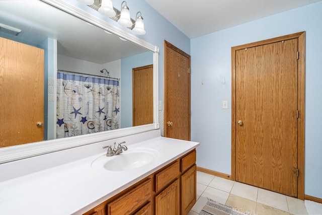 bathroom featuring tile patterned flooring, vanity, and curtained shower