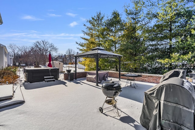 view of patio / terrace with a hot tub, a gazebo, and a grill