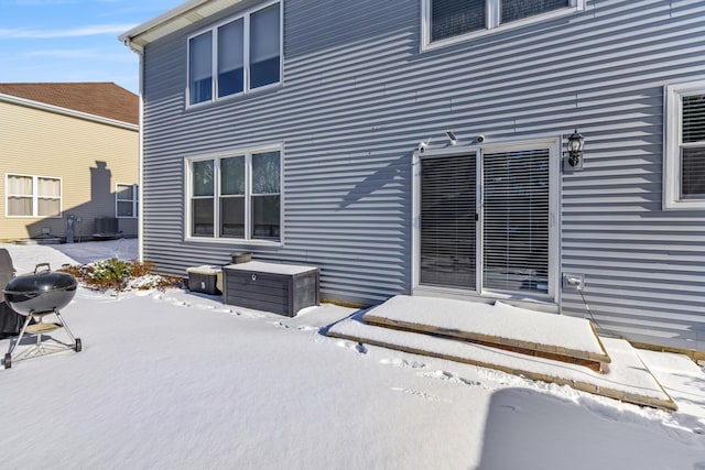 snow covered property with central air condition unit