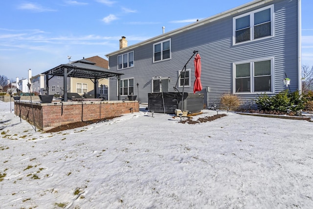 back of property featuring a gazebo