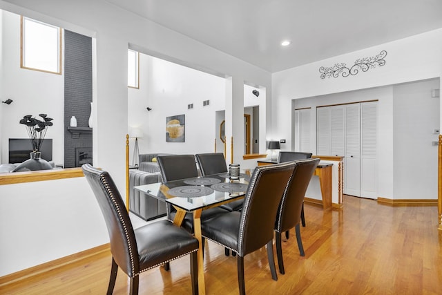 dining room with a fireplace and light hardwood / wood-style floors