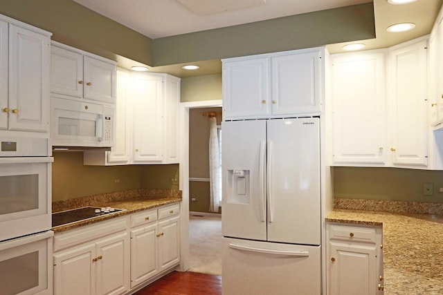 kitchen featuring white appliances, recessed lighting, light stone counters, and white cabinets