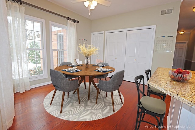 dining area featuring a ceiling fan, a healthy amount of sunlight, visible vents, and wood finished floors