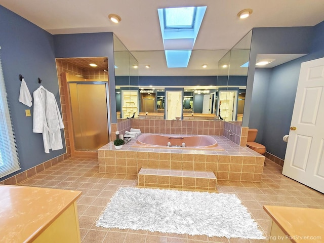 full bath with a stall shower, a skylight, baseboards, tile patterned floors, and vanity