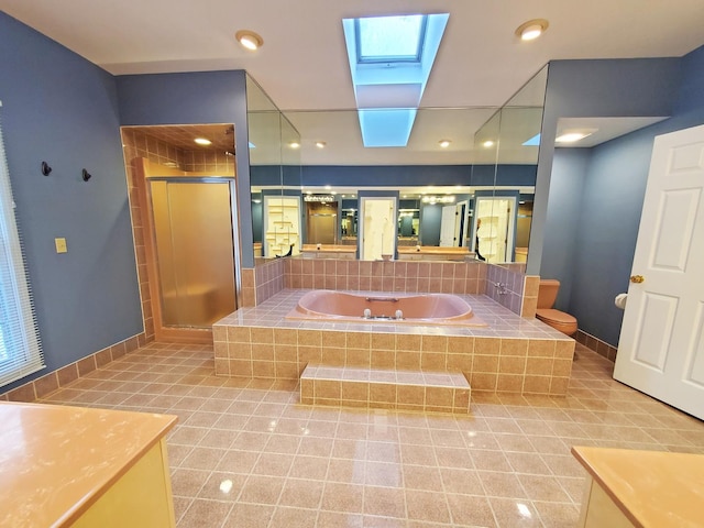 bathroom with a stall shower, tile patterned flooring, a skylight, and baseboards