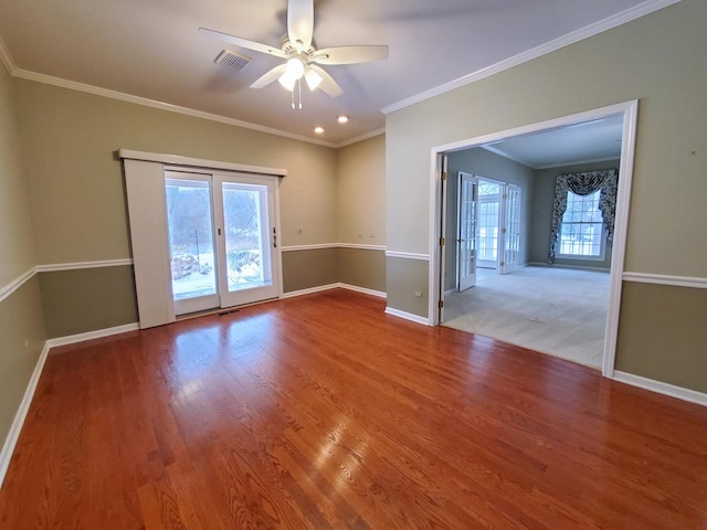 unfurnished room with baseboards, crown molding, visible vents, and wood finished floors