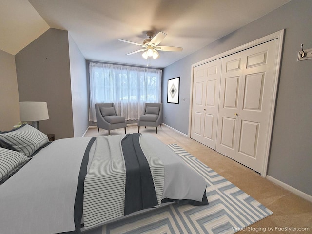 bedroom featuring light carpet, ceiling fan, baseboards, and a closet