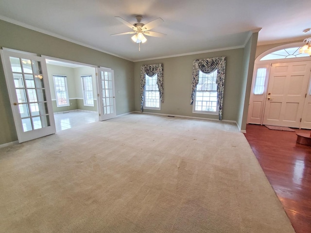 interior space with a ceiling fan, carpet, crown molding, and baseboards