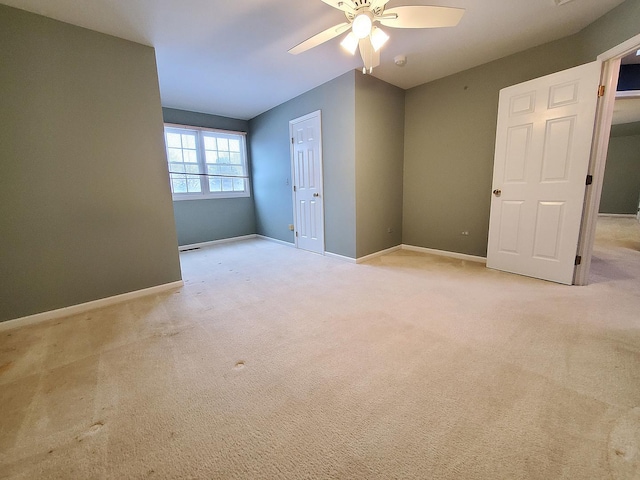 empty room with light carpet, ceiling fan, and baseboards