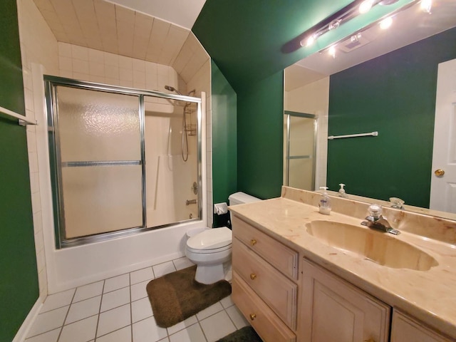 full bathroom with combined bath / shower with glass door, vanity, toilet, and tile patterned floors