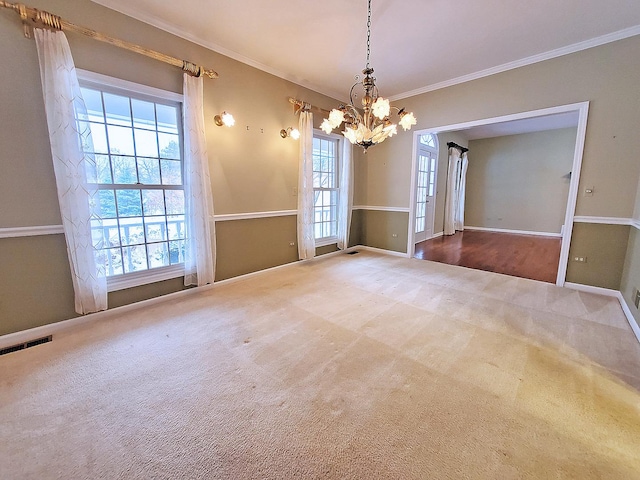 carpeted empty room with baseboards, an inviting chandelier, visible vents, and crown molding