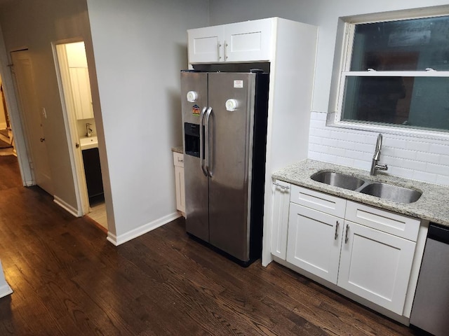 7715 S Paxton Ave, Chicago, IL 60649 - kitchen featuring appliances with stainless steel finishes, a sink, dark wood-style floors, and light stone counters